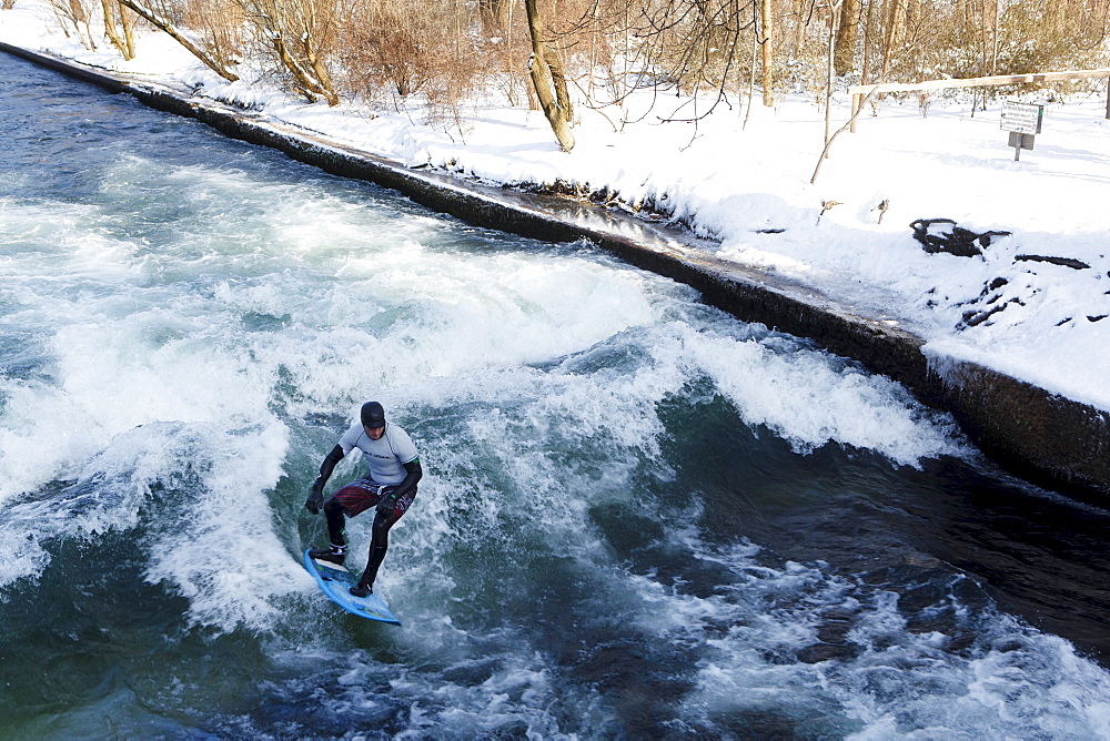 Surfer on Eisbach in winter, English Garden, Munich, Bavaria, Germany