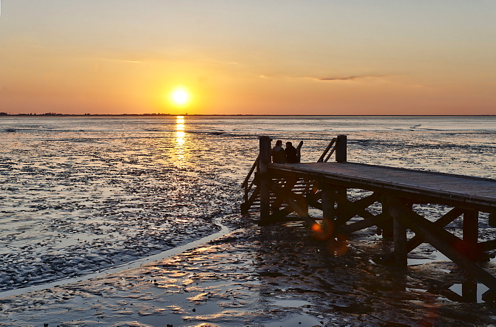 Couple watching the sunset, Schleswig-Holsteinisch Wadden Sea National Park, Husum, Schleswig-Holstein, Germany