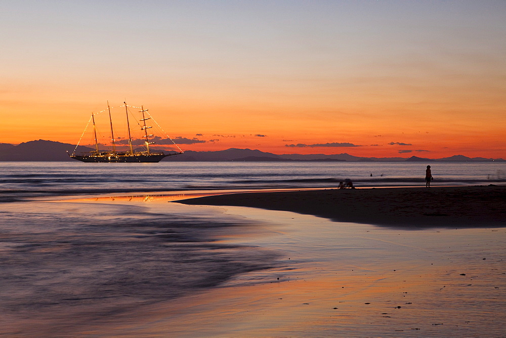 People on beach and sailing cruiseship Star Flyer (Star Clippers Cruises) at sunset, Puerto Caldera, Puntarenas, Costa Rica, Central America, America