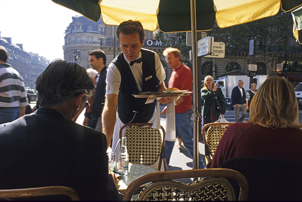 Waiter serving coffee at a CafâˆšÃ‰Â¬Â© in Paris, France