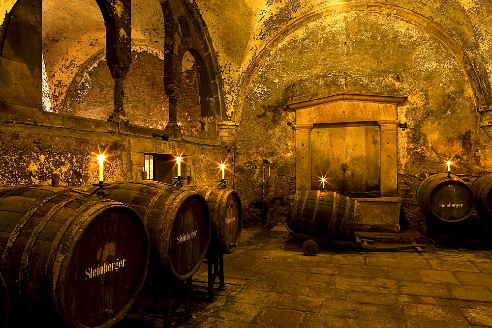 Candlelit barrels inside wine cellar of Eberbach abbey, a medieval monastery at Eltville am Rhein, Rheingau, Hesse, Germany, Europe