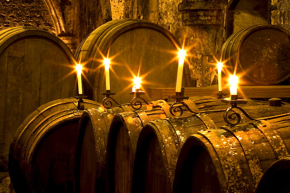 Candlelit barrels inside wine cellar of Eberbach abbey, a medieval monastery at Eltville am Rhein, Rheingau, Hesse, Germany, Europe