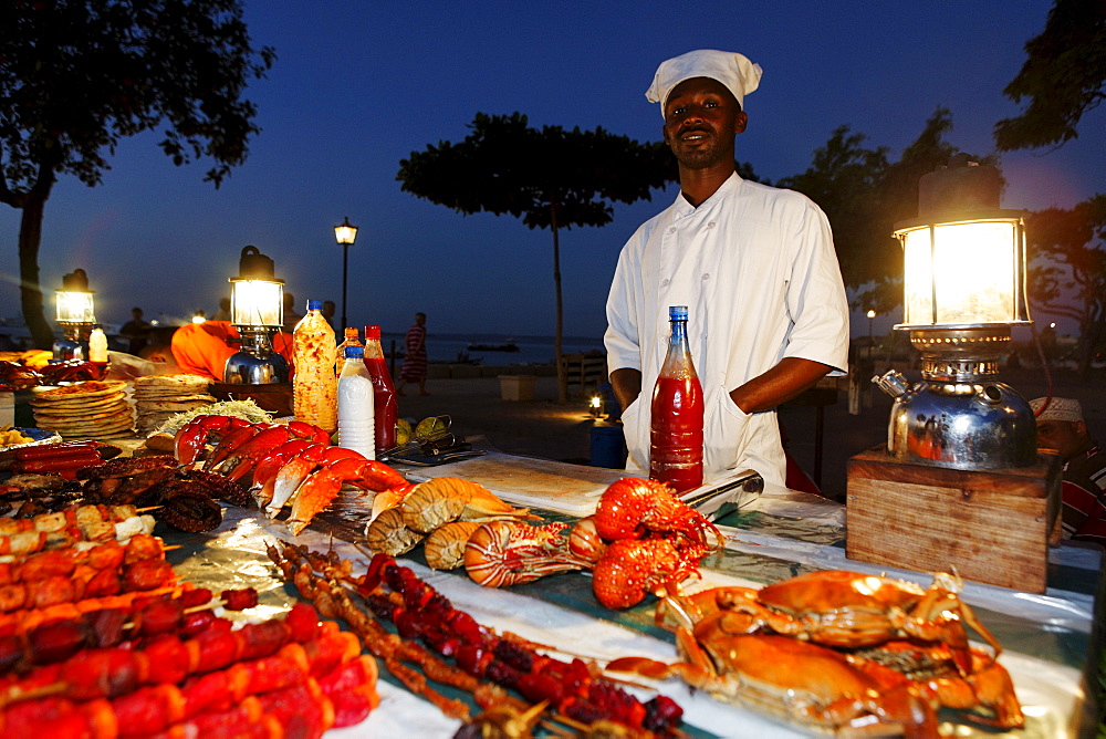 Monger at a stand, night market at Forodhani Gardens, Stonetown, Zanzibar City, Zanzibar, Tanzania, Africa