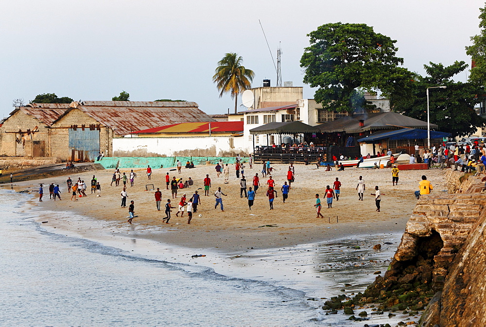 Children playing soccer on the beach in front of Mercury's restaurant, Stonetown, Zanzibar City, Zanzibar, Tanzania, Africa