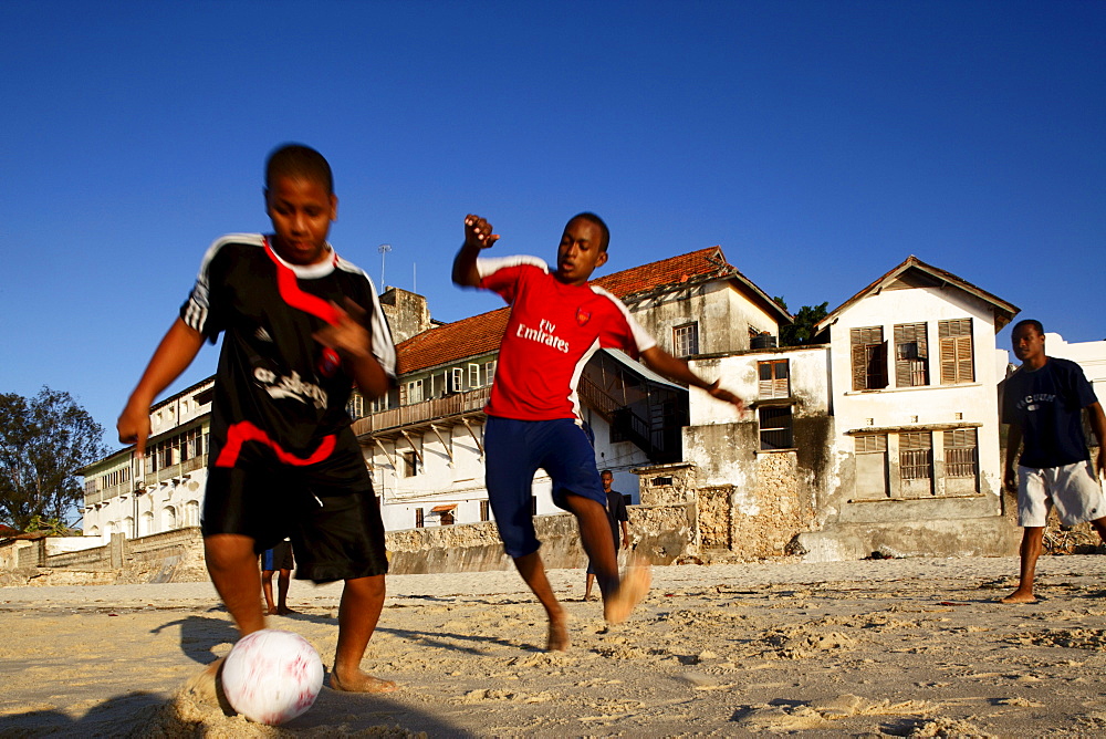 Children playing soccer on the beach of Stonetown, Zanzibar City, Zanzibar, Tanzania, Africa