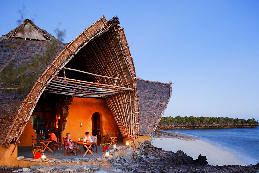 People in front of the Chumbe Island Coral Park Lodge at dusk, Restaurant in the Visitor Center, Chumbe Island, Zanzibar, Tanzania, Africa