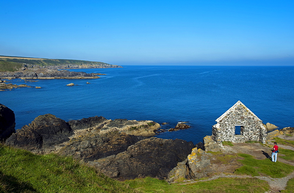 Tourist at a ruin above the harbour of Portsoy, Aberdeenshire, Scotland