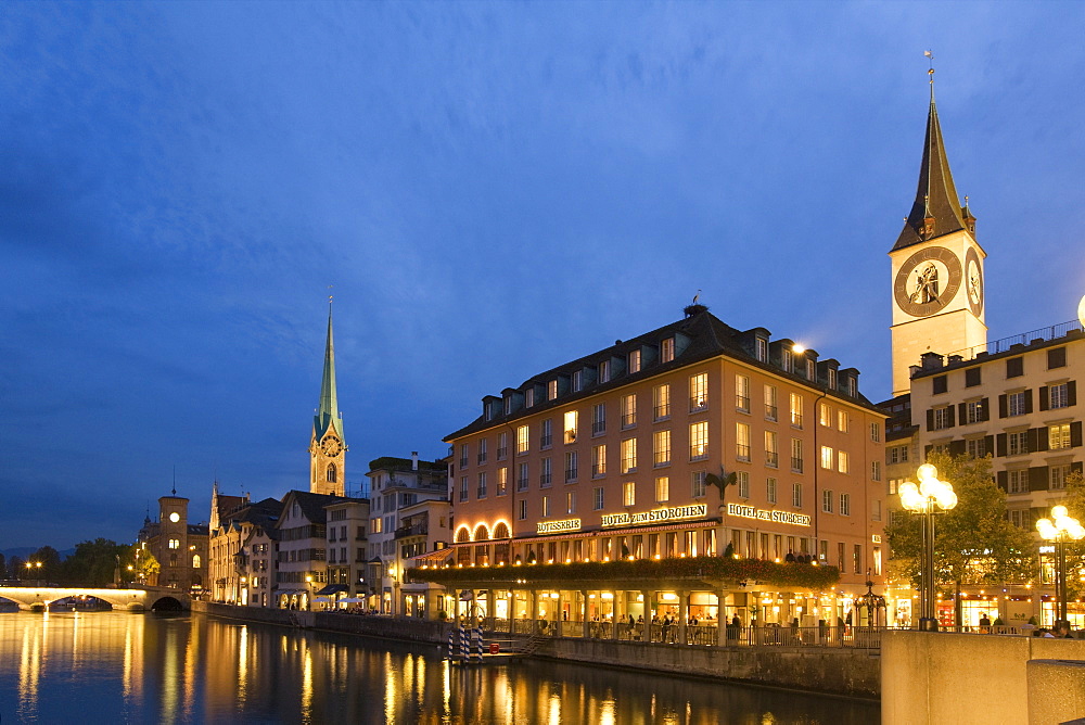 Switzerland, Zurich, old town center, river Limmat at night, left side Fraumunster church, right side St. Peters church, Hotel Storchen