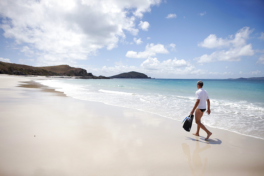 Tourist with snorkelling gear on Middle Island beach, Island next to Great Keppel Island, Great Barrier Reef Marine Park, UNESCO World Heritage Site, Queensland, Australia