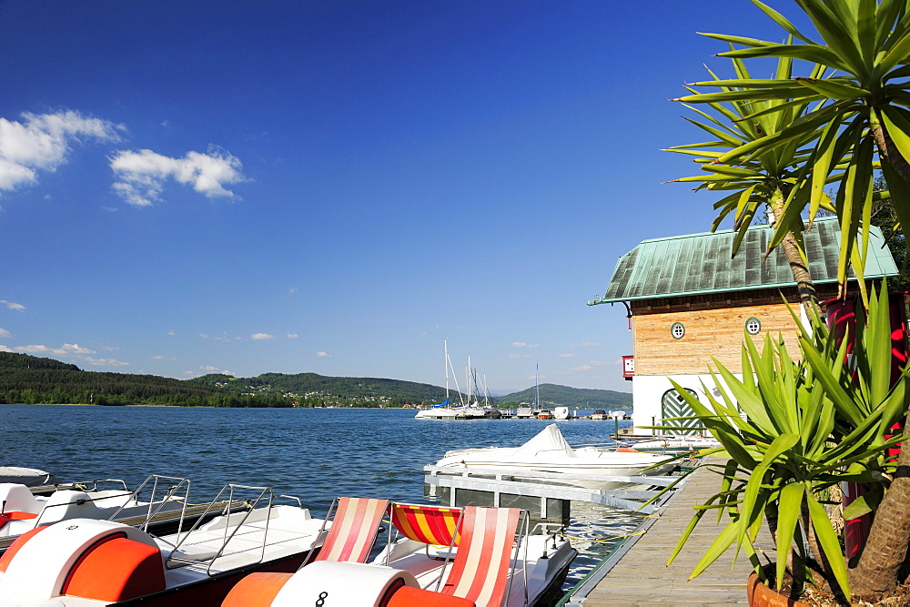 Wooden landing stage with sailing boats and pedal boats, lake Woerthersee, Carinthia, Austria, Europe