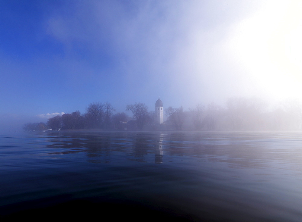 Misty scenery with tower of Frauenwoerth monastery in the background, Frauenchiemsee, Fraueninsel, Chiemgau, Bavaria, Germany