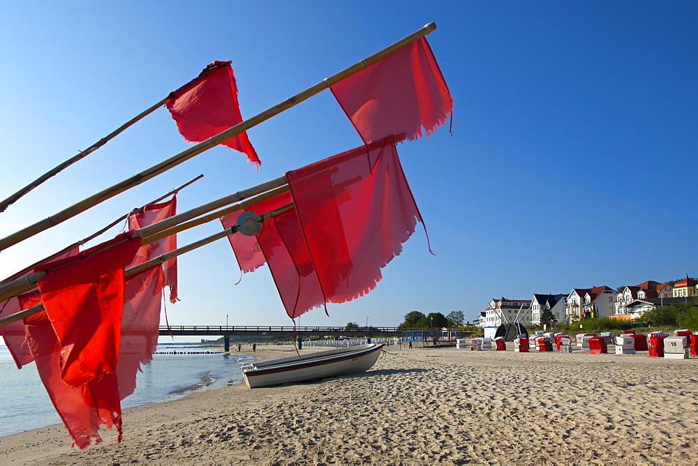 Fishing boat and red flags on the beach, Bansin seaside resort, Usedom island, Baltic Sea, Mecklenburg-West Pomerania, Germany