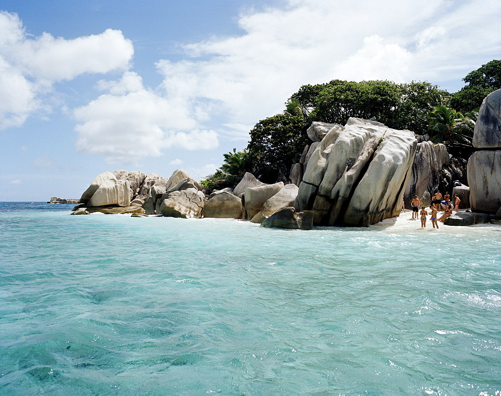 Tourists on the beach of tiny Coco Island, La Digue and Inner Islands, Republic of Seychelles, Indian Ocean