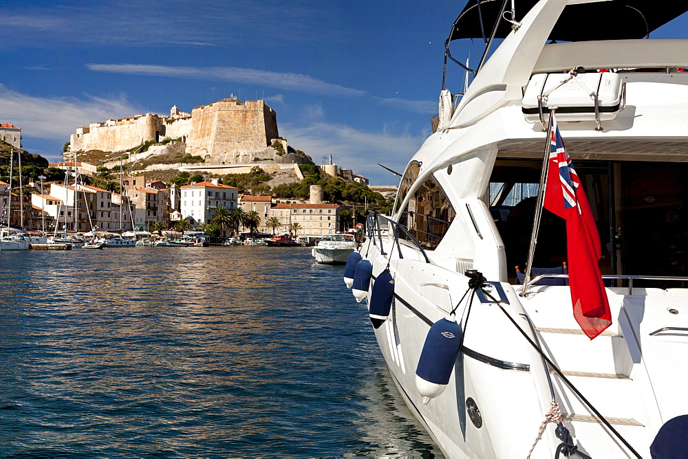 Boat with Union Jack in harbor, citadel, Bonifacio, Corsica, France