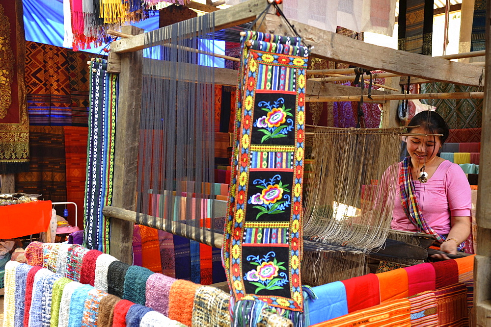 Young woman working on handmade silk fabrics in a village nearby Pak Ou caves obove Mekong river north of Luang Prabang, Laos