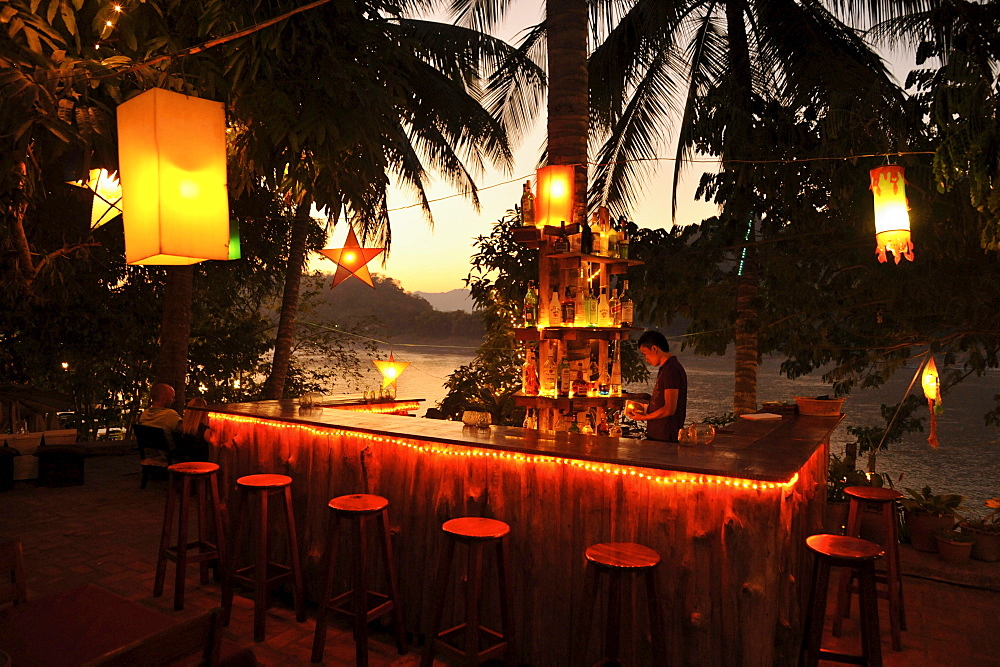 Bar under palm trees, Mekong river after sunset, Luang Prabang, Laos