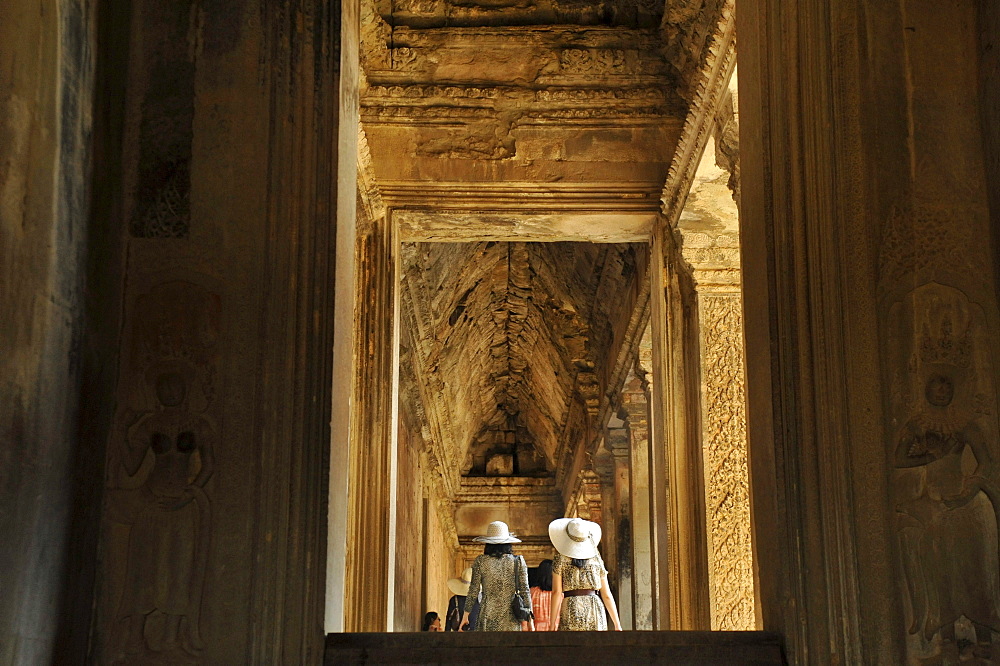 Japanese tourist wearing hats in the entance galeria, Angkor Vat, Angkor, Cambodia, Asia