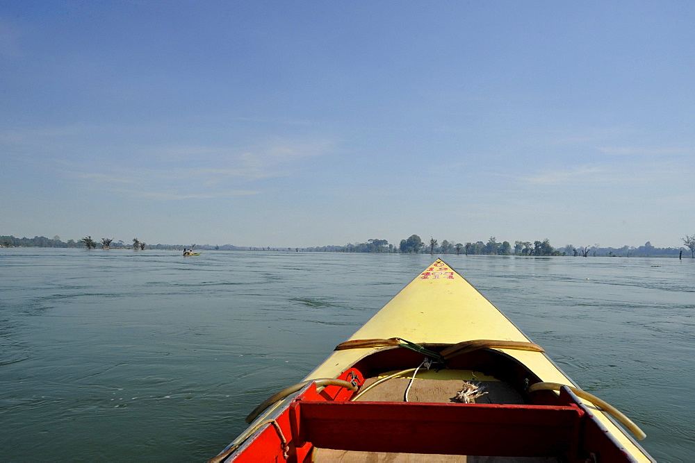 Boat and trees in Mekong river north of Stung Teng, Cambodia, Asia