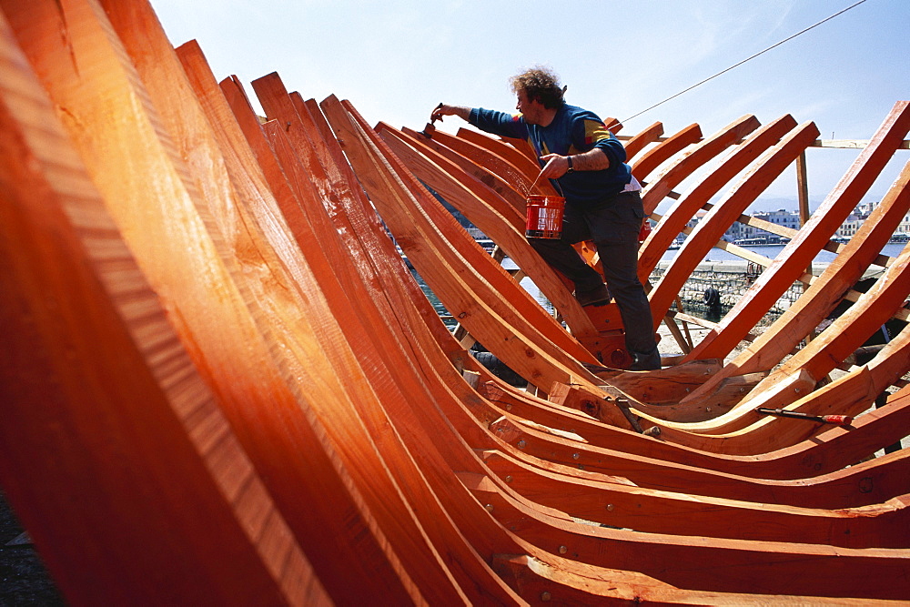 Man building a boat at the harbour of Chania, Crete, Greece, Europe