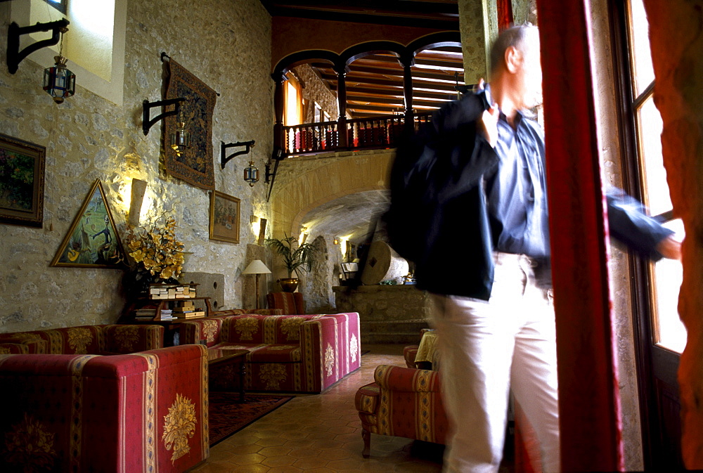 A mature man standing in the parlour of Finca Monnaber Nou, Tramuntura, Majorca, Spain