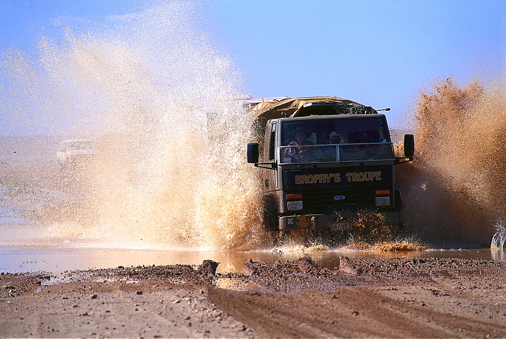 Truck of Fred Brophy's Boxing Troupe driving through water, Outback, Australia