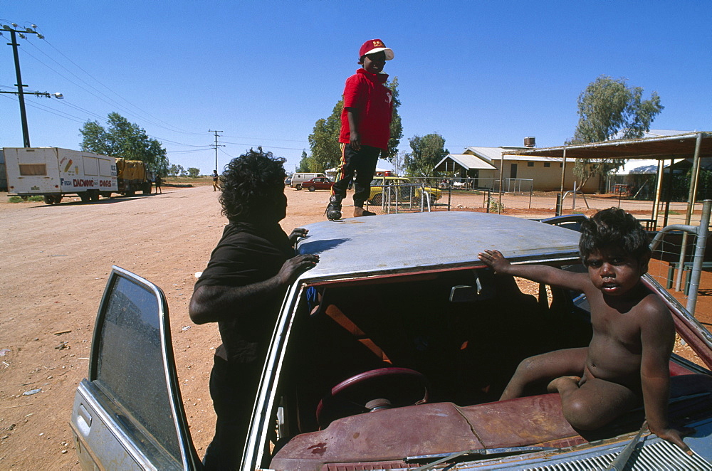 Kids playing on car, Community Lake Nash, Northern Territory, Australia