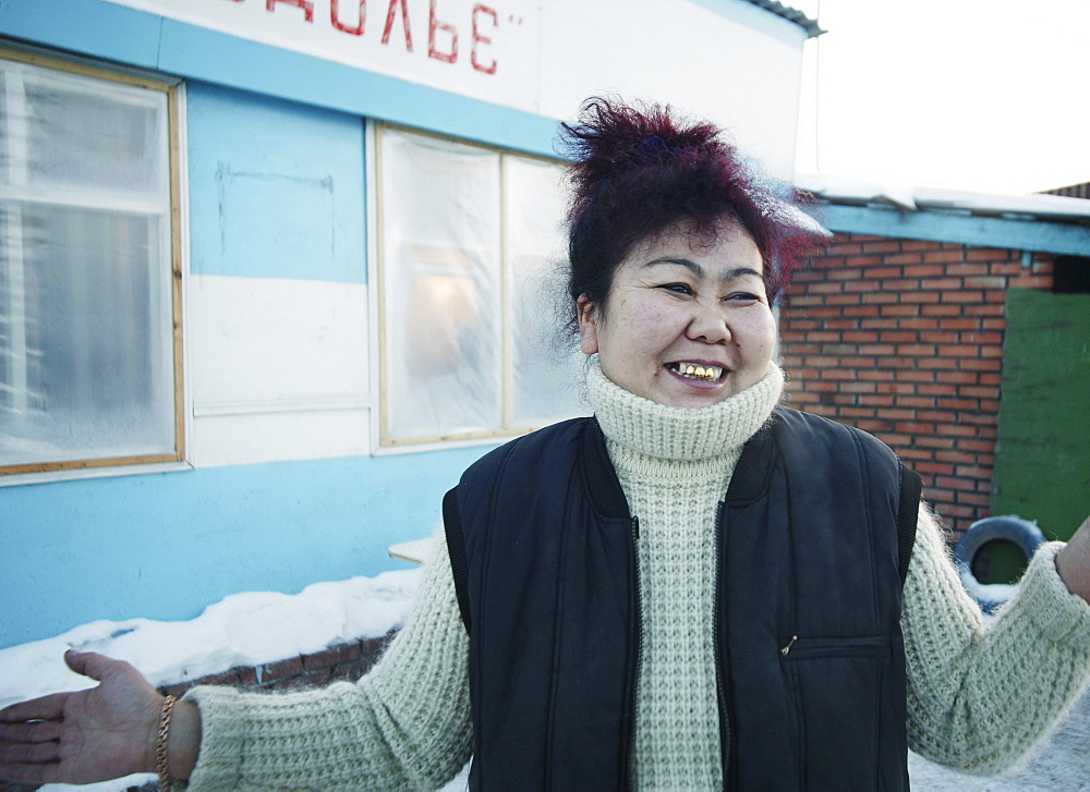 Smiling woman standing in front of a house, Omsk, Siberia