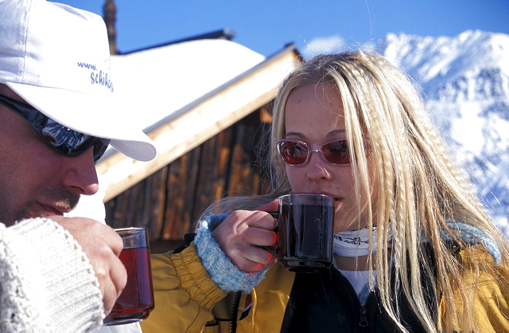 Couple having a warm drink at the Obstlerhuette, Soelden, Oetztal, Tyrol, Austria