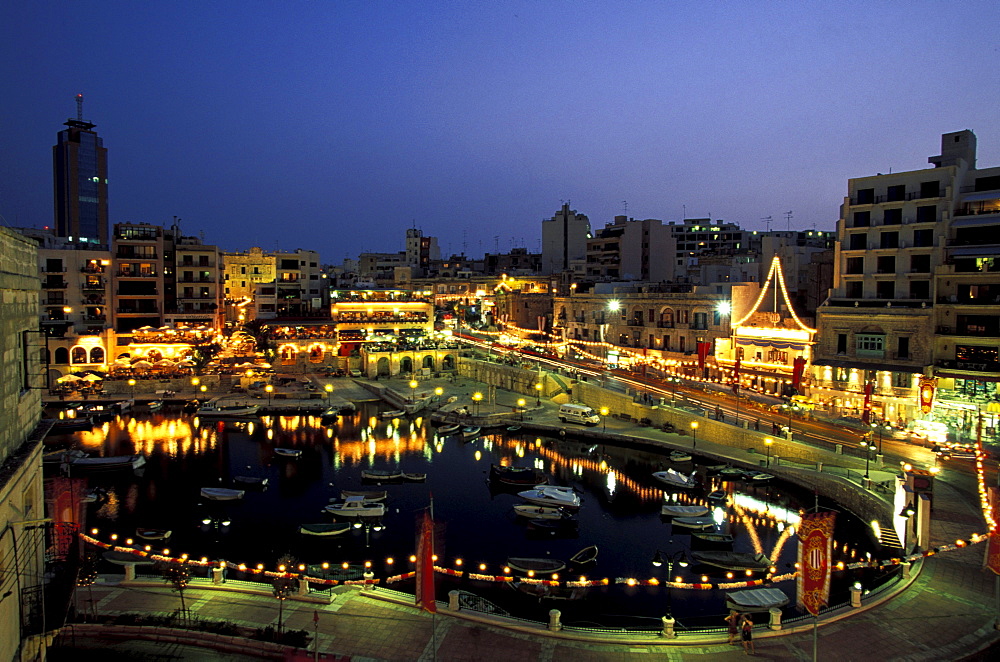 View of illuminated restaurants in the evening, Spinola Bay, Malta, Europe