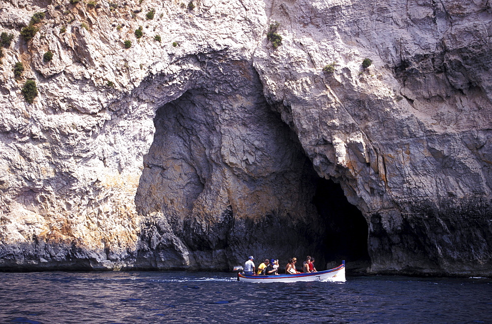 Tourists in a boat in front of the Blue Grotto, Malta, Europe
