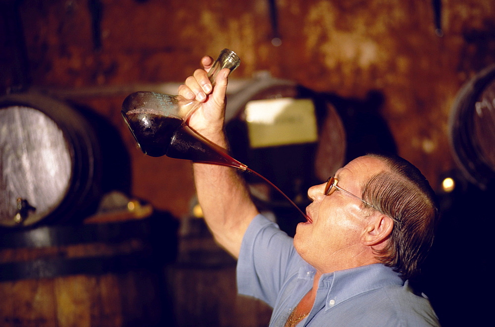 Wine tasting with a porron, a traditional glass wine pitcher, typical of Catalonia, Vilafranca del Penedes, Catalonia, Spain