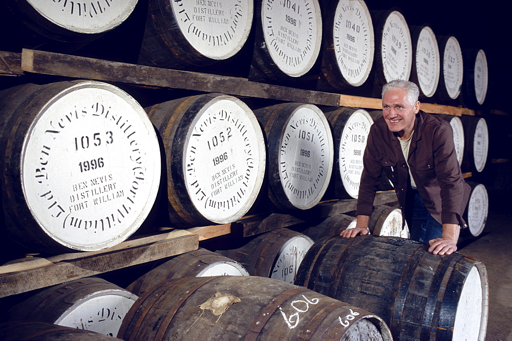 Man rolling barrels at Ben Nevis distillery, Fort William, Invernesshire, Scotland, Great Britain, Europe