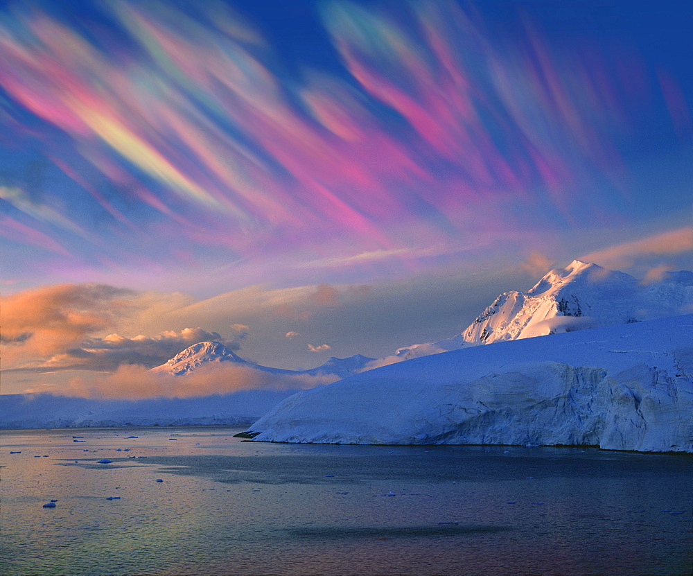 Mother of pearl clouds, nacreous clouds over snow covered iceberg, Antarctic Peninsula, Antarctica