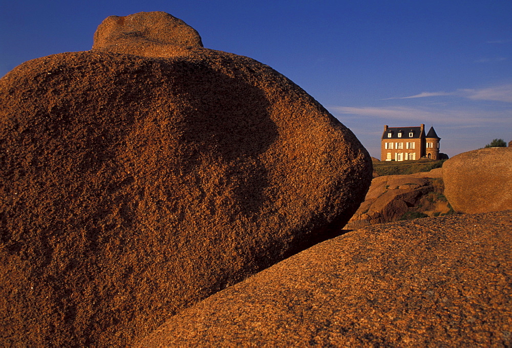 House on limestone boulders in the sunlight, Cote de Granit Rose, Brittany, France, Europe