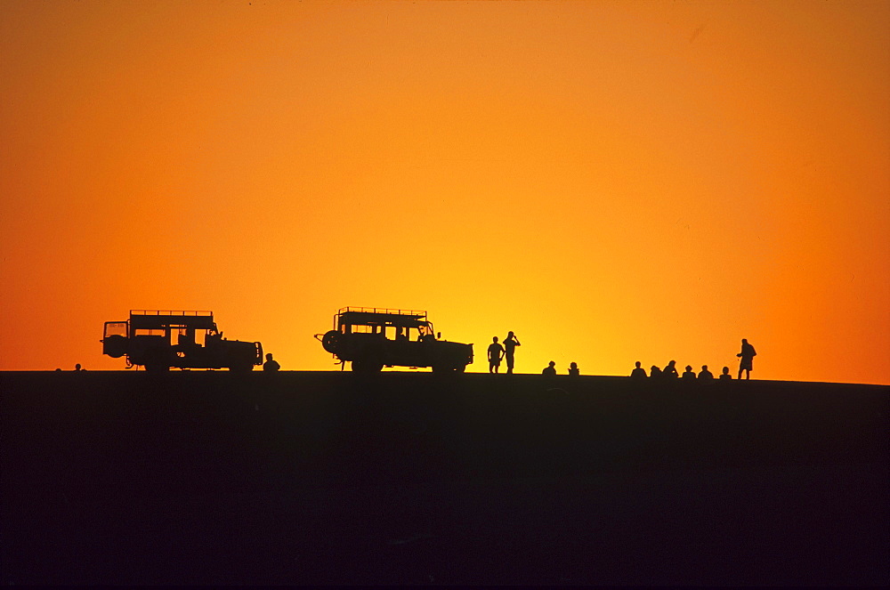 Jeeps and people at sunset, Walvis Bay, Namibia, Africa