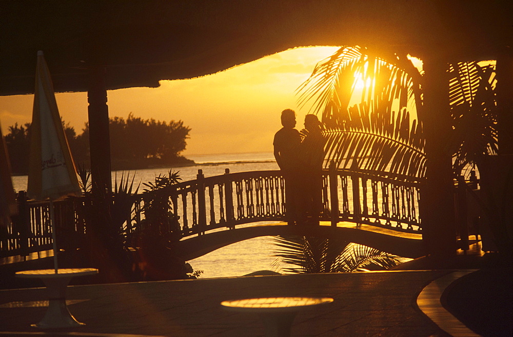 Couple on bridge against sunset, Royal Palm Hotel, Mauritius