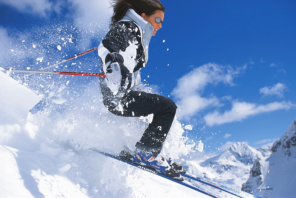 Freeriding, a woman skiing in front of blue sky