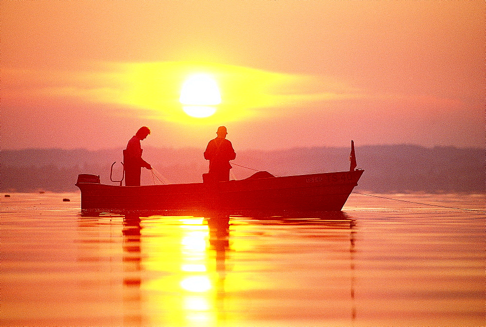 Two men fishing at lake Chiemsee, Upper Bavaria, Germany