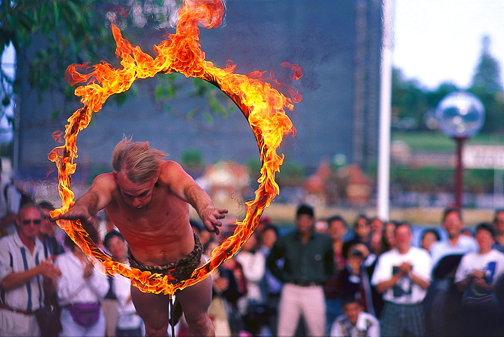 Street artist jumping through a ring of fire, The Rocks, Sydney, NSW, Australia