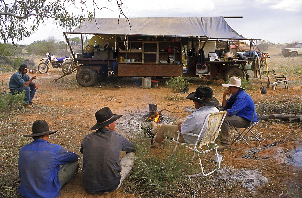 Stockmen sit around the cooks kitchen trailer, Kidman Station, South Australia, Australia