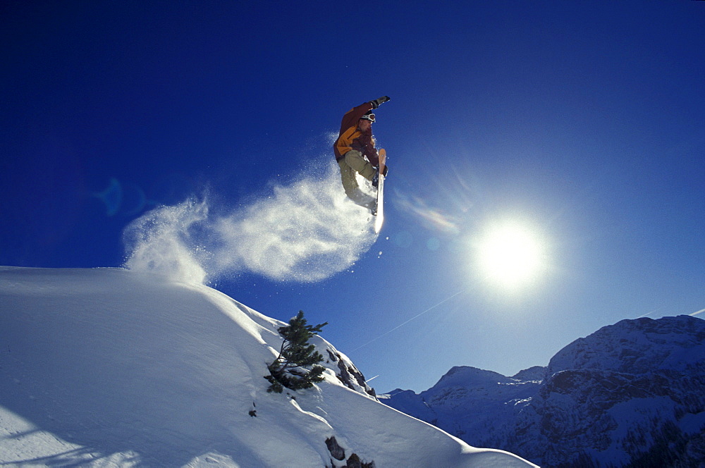 A snowboarder during a jump in front of a blue sky