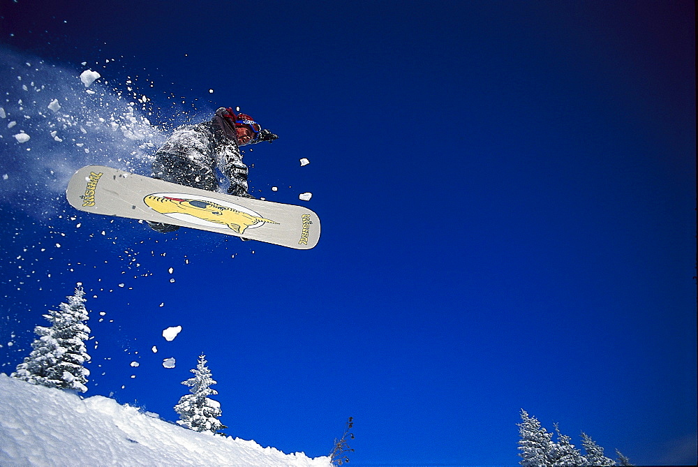 Snowboarder during jump under blue sky, Vorarlberg, Austria, Europe