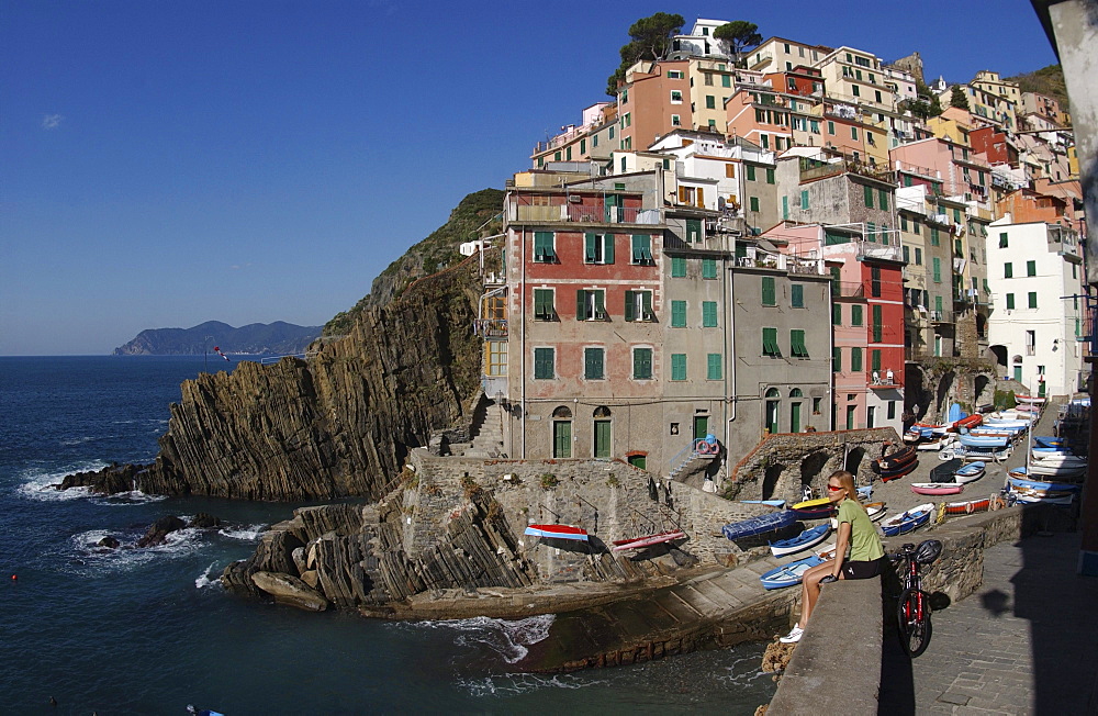 A woman enjoying a break at the harbour, Riomaggiore, Cinque Terre, Italy