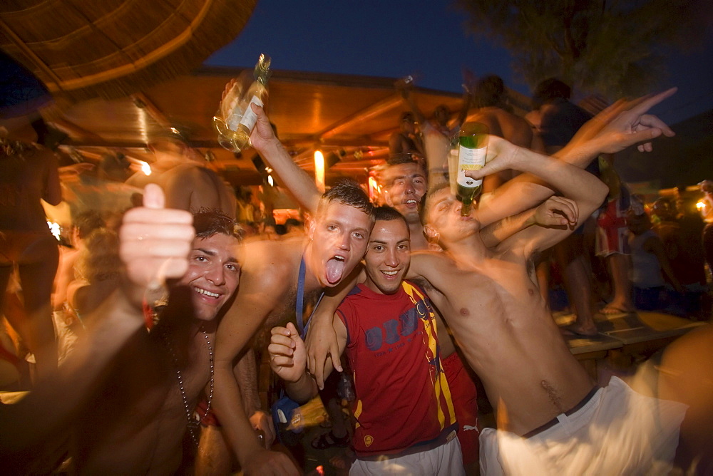 Men amusing during the Full Moon Party of the Tropicana Club, Paradise Beach, Mykonos, Greece