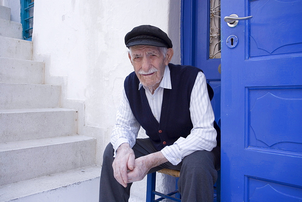 A local old man sitting in front of a white house, Mykonos-Town, Mykonos, Greece