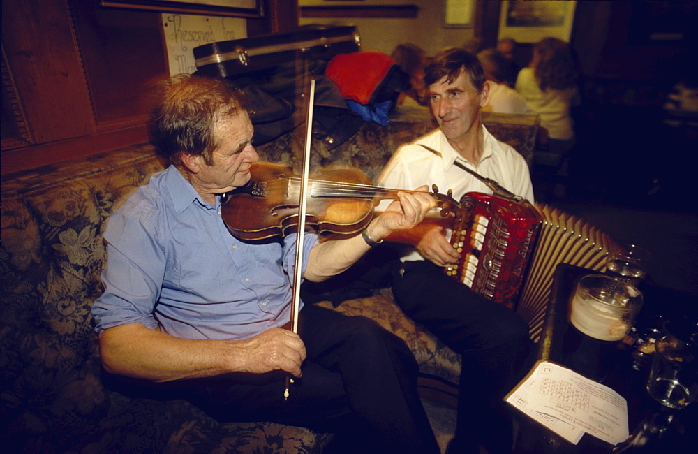 Two men playing traditional music on violin and accordion in Gus O'Connor's Pub, Doolin, County Clare, Ireland00058539