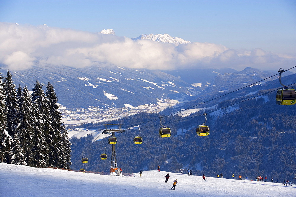 Achter Jet, 8-seated cabin cable car, Austria's 1st mono-cable aerial ropeway, skiers on slope, summit of the Dachsteinregion at horizon, Flachau, Salzburger Land, Austria