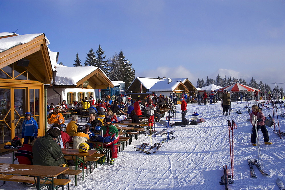 Skiers sitting in front of the Birkhahnalm and Griessenkarhaus, Flachau, Salzburger Land, Austria