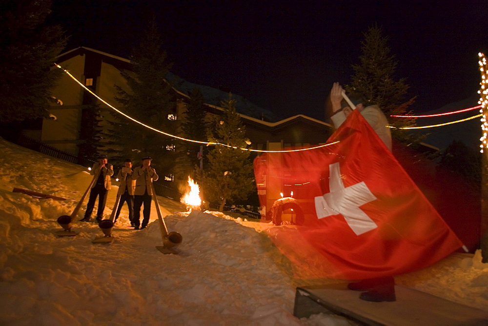 A flagswinger and swiss horn players at night, Saas-Fee, Valais, Switzerland