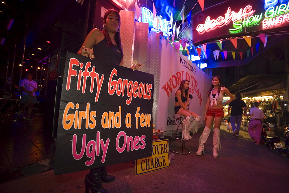 Three Go-go girls in front of a nightclub, one woman holding a sign, Patpong, red light and entertainment district, Bang Rak district, Bangkok, Thailand